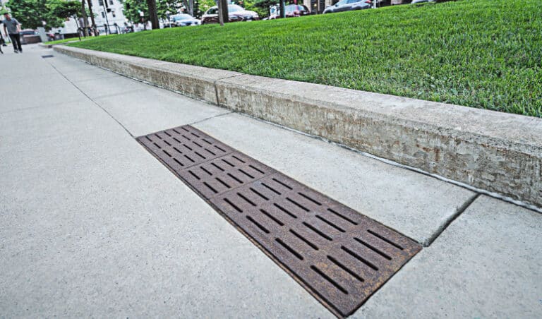 Drainage trench made of cast iron on concrete walkway